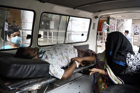 A relative transports a Covid-19 patient to Dhaka Medical College Hospital for admission to get treatment during the coronavirus pandemic in Dhaka.