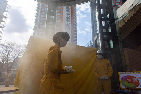 Mori Building first aid treatment diffusers seen standing next to a smoke tent during the disaster drill in Roppongi Hills. Japanese employees of Mori Building Company participate in a disaster drill in Roppongi Hills in Tokyo to get familiar with fire extinguishing, first aid and smoke build-up situations.