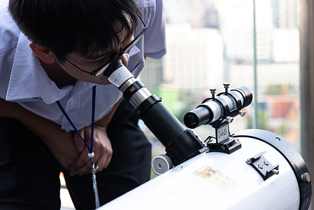 A man observes the sky with a telescope before the total lunar eclipse appears during an astronomical event in Bangkok. A total lunar eclipse is seen across Thailand, including Bangkok, The blood moon appear in the sky over the Bangkok during 6.23 pm.