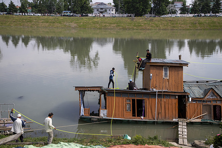 Men work to restore a partially submerged houseboat following gusty winds and heavy rainfall in Srinagar, the summer capital of Jammu and Kashmir. The local weather office has warned of the possibility of thunderstorms, lightning, hailstorms, and gusty winds with speeds of 40–50 kmph, gusting above 60 kmph, at a few places in both Kashmir and Jammu divisions during May 21 and 22.