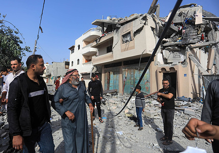 Palestinians inspect the damage to a house hit by the Israeli airstrikes in Khan Yunis, in the southern Gaza Strip.