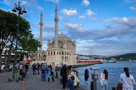 People spend time near Ortakoy Mosque on Ortakoy square in Besiktas district in Istanbul.