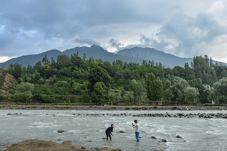 Visitors take photos in a stream during cloudy weather in Ganderbal, about 30kms from Srinagar, the summer capital of Jammu and Kashmir.