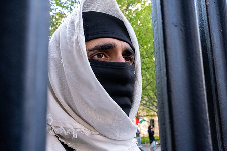 Portrait of one of the protest leaders shot through the gates. Pro-Palestine students occupy Hamilton Hall overnight causing Columbia University to restrict access to the campus. Protesters are demanding that university “divest all of its finances, including the endowment from companies and institutions that profit from Israeli apartheid, genocide, and occupation in Palestine”