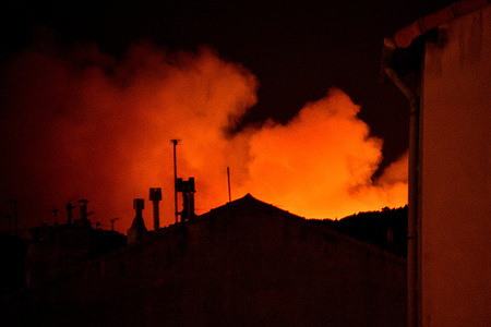 Smoke from the fire is illuminated by the flames above the rooftops in the hills above the town of Rove. A fire broke out around 3:30 a.m. in the hills above the town of Rove, near Marseille, requiring the intervention of 200 firefighters from the department and 50 marine firefighters.