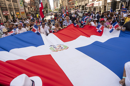 Participants march with a large Dominican Republic flag at the Dominican Day Parade on 6th Avenue on August 10, 2025 in New York City. The National Dominican Day Parade celebrated 43 years of marching on Sixth Avenue in Manhattan. The parade celebrates Dominican culture, folklore, and traditions.