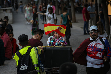 A child carrying a Spanish flag dressed in a typical Bolivian costume dances during the demonstration. Immigrant groups have demonstrated in the center of Madrid to protest during the Spanish National Holiday on October 12, which celebrates the discovery of America. The motto of the demonstration was: "October 12, nothing to celebrate".
