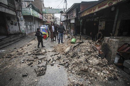 Palestinians inspect the destroyed commercial market in Balata refugee camp in the West Bank, which was demolished by Israeli army bulldozers during a military operation. The destruction affected infrastructure, sewage systems, the central market, and shops. During the operation, an entire Palestinian family was arrested as their son, Obada Rawajbeh, was sought by the Israeli army for surrender.