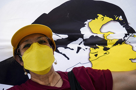 A woman looks on while holding a flag depicting Saint Oscar Romero during a procession to the San Salvador cathedral. On March 24th 1980 Archbishop Oscar Romero was assassinated by death squads while presiding at a memorial mass at the Divina Providencia chapel.