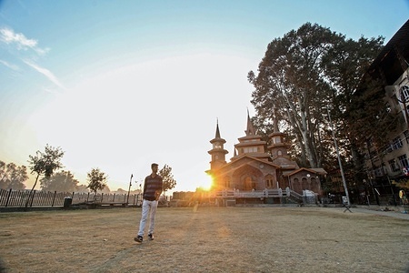A Kashmiri resident seen walking in the park at sunset time on an autumn day in Srinagar, Indian administered Kashmir. Kashmir is the northernmost geographical region of the Indian subcontinent. It is currently a disputed territory, administered by three countries: India, Pakistan and China.