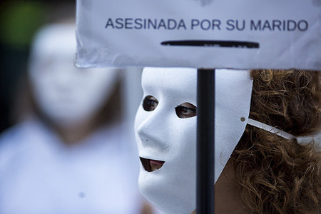A woman wearing a mask and white tunic holds a placard with the details of Maria del Carmen, murdered by her husband on January 12, 2026, during a demonstration by the Somos Ellas Madrid collective, banners bore the names of the 32 women who have been murdered in Spain so far in 2026. The Feminist action aims to raise awareness about the victims and denounce gender violence.