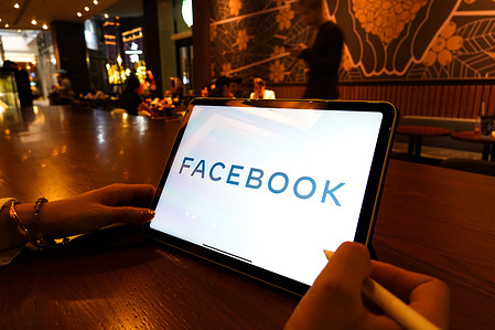 In this photo illustration, a Facebook logo is displayed on the screen of an iPad.