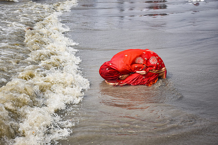 A devotee is seen praying in the sea at Gangasagar.
Gangasagar is a place of Hindu pilgrimage where each year on the day of Makar Sankranti (January 14th) thousands of Hindus gather to take a sacred dip at the convergence of the river ganga and Bay of Bengal. After the dip, all pilgrims offer prayer at the Kapil Muni temple.
