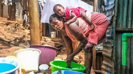 Keisha seen laying comfortably on her mum's back as her mum does the Laundry in Kibera.
Kibera is one of Africa’s largest Slums located in East Africa, Kenya.
