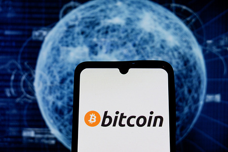 In this photo illustration, the Bitcoin logo seen displayed on a smartphone.
