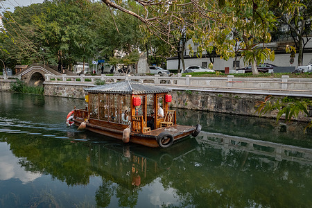 A wooden boat with red lanterns floats on a river.