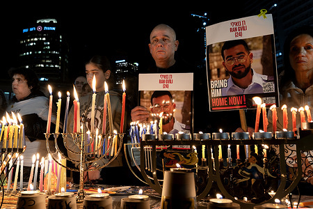 Many people attend the final Hanukkah candle-lighting ceremony at Hostages Square, carrying photos of the last fallen hostage still held by Hamas. The eighth and final Hanukkah candle was lit at Hostages Square in a ceremony calling for the return of the last fallen hostage, Ran Goyali, still held by Hamas. The event was attended by his family and by the families of former hostages who have returned to Israel.