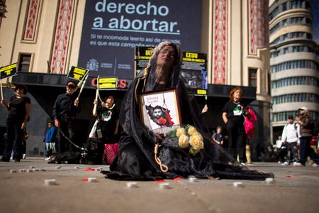 A woman holds a portrait, wearing a veil on her head during a rally against the death penalty in Callao Square in central Madrid. World Day Against the Death Penalty has been observed every October 10th since 2003.