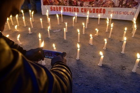 A Kashmiri boy take pictures during a candlelight vigil to protest against the violence in Syria in Srinagar, Indian administered Kashmir. A candlelight vigil was held in solidarity with the Muslims of Syria, who are brutally being killed by the Israeli forces. Scores of the protestors assembled at press colony, Srinagar to express the solidarity with the people of Syria. Over 500 people were killed in Eastern Ghouta in the week leading up to a fragile truce between Assad's regime and his allies with rebels controlling the territory.