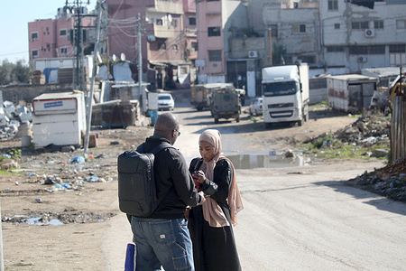 Palestinian seen standing in the street while Israeli military vehicles are visible in the background during a raid on the Askar refugee camp east of Nablus in the West Bank. Israeli forces raided Palestinian homes and shops inside the camp searching for Palestinian militants. One Palestinian was injured during the search.