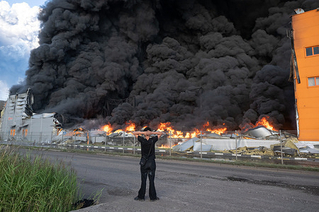 A man looks at the burning warehouse of the Russian online retailer Wildberries in the Utkina Zavod area, near the village of Novosaratovka, after it caught fire following a drone attack. During the night of July 24, the Armed Forces of Ukraine launched a large-scale drone attack targeting warehouses of the Russian online retailer Wildberries in the Leningrad Region and St. Petersburg, Russia.