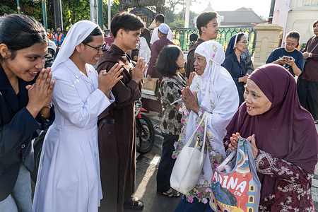 People from the Catholic Church of Sacred Heart of Jesus greet Muslims after the prayers. Muslims performed Eid al-Fitr prayer at Jami’ Grand Mosque square in Malang, East Java, Indonesia. Eid al-Fitr is a holiday in the Islamic calendar that marks the end of Ramadan and the first day of Shawwal.