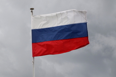 The flag of Russia flutters in the wind at the Russian Federation, the city of Veliky Novgorod on a motor ship.