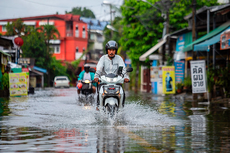A motorcyclist rides through a flooded area after continuous heavy rainfall in Chiang Mai, Thailand. Chiang Mai has been experiencing continuous heavy rain, causing flooding in several parts of the city. Some areas are also at risk of flash floods. Relevant authorities are working to drain the water and have advised the public to exercise caution when traveling during this period.