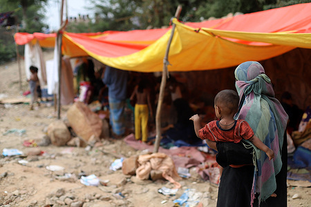 A woman seen with a kid outside the camp area, during the aftermath.A fire incident broke out at the Rohingya refugee camp leaving over 50 shanties of Rohingya refugees gutted. The cause of the fire has not yet been established.