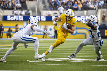 Los Angeles Chargers wide receiver Ladd McConkey #15 runs the ball fighting off pressure from Indianapolis Colts safety Camryn Bynum #0 and cornerback Kenny Moore II #23 during an NFL football game at SoFi Stadium. Indianapolis Colts 38: 24 Los Angeles Chargers