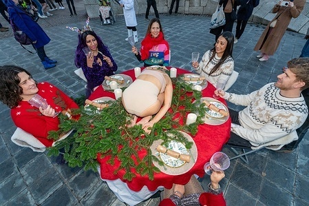 Activists seen sitting around a table.
christmas, x-mas, holidays Vegan activists from Speciesism WTF staged an artistic demonstration in Southbank, gathering around a table set for a Christmas dinner with a semi-nude performer placed in the centre to symbolise a turkey. The performance is part of the “Turkey Is NOT Human(e)” campaign highlighting the suffering of millions of turkeys raised for Christmas and drawing attention to the conditions in which they are bred, confined, and slaughtered while urging the public to reconsider traditions that perpetuate animal cruelty.