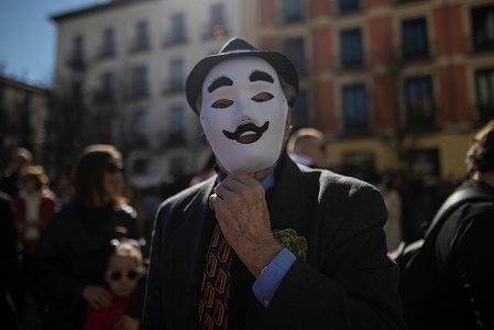 People wearing white masks as part of the performance attend the 1st Madrid Masquerade Parade. during the 1st Masquerade Parade through the center of Madrid, organized by the regional associations of Asturias, Galicia, and Zamora, the heart of the Spanish capital was transformed into a stage for ancestral rites from the Spanish regions of Asturias, Galicia, and Zamora.
