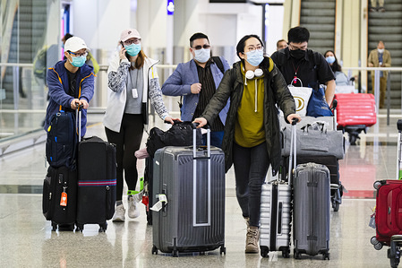 Passengers wear protective masks amid Coronavirus threats at the Hong Kong International Airport.
In response to the latest situations of Covid-19 Pandemic, all people who have been to all overseas countries/territories in the past 14 days prior to arrival in Hong Kong, regardless of whether they are Hong Kong residents, are required by law for compulsory self-quarantine and to wear electronic bracelets, connected to an app to mark your location for two weeks.