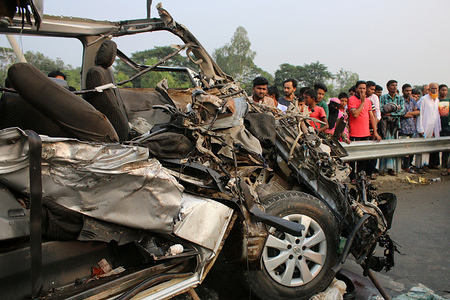 Wreckage of a microbus seen after a bus hit it head-on at the Dhaka-Mawa Highway in Munshiganj.
At least ten people, including two women and two children, were killed and four others injured as a bus collides with a microbus. The accident took place on Dhaka-Mawa highway when a microbus carrying a groom’s party was heading towards Dhaka from Munshiganj around 2:00pm. The police official also said that the mishap occurred as the speeding bus of Swadhin Paribahan was overtaking another bus on the road.