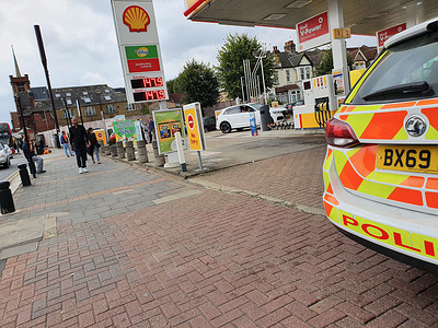 Pedestrians walk past a filling station in East London guarded by police after supplies run out due to the looming fuel supply crisis.
The RAC (Royal Automobile Club) warned that average prices may hit 143p per liter for petrol and 145p per liter for diesel, up from the the current level of 135p per liter for petrol and 138p per liter for diesel.​ ​The highest average price for petrol is 142p per liter, which was recorded in April 2012.
