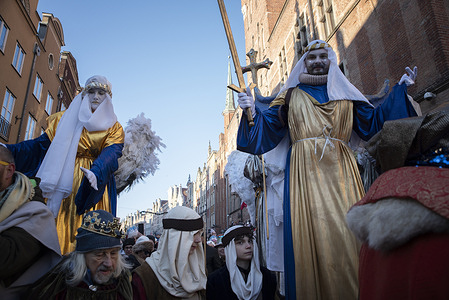 Artists dressed as angels walk on stilts through the streets of the city during the Three Kings Procession in Gdansk. The Three Kings Procession passed through the streets of Gdańsk. Epiphany is one of the oldest Christian holidays. On this day, a mass is celebrated, and processions of the three kings appear on the streets of towns and villages. In Gdańsk, the procession started from St. Mary's Basilica. The entire procession was spectacular. There were elaborately dressed kings, stilt walkers, and artistically costumed groups. Crowds of residents and tourists sang Christmas carols.