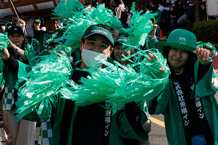 Members of a group representing Toyoko Inns wave green pompoms as they take part in the 30th Saint Patrick's Day event in Omotesando. This is the largest and oldest St Patrick's Day event in Asia and features hundreds of musicians, dancers and performers.