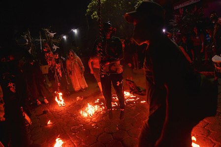 Revelers gesture while dancing in a fire circle during the celebration.
Salvadorans celebrated traditional "La Calabiuza" where revelers dress up as characters from local folklore on the eve of "Día de los Muertos".