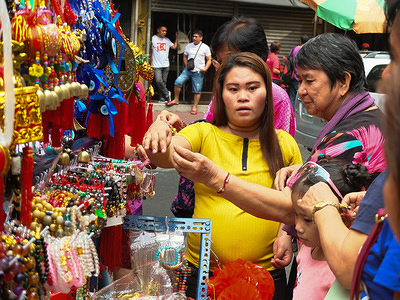 A woman seen choosing a lucky charm ornament that she will buy for the New year celebration.
Filipinos and Filipino-Chinese celebrate Chinese New Year by visiting Binondo to enjoy dragon dances, fireworks and shopped Chinese foods such as much-loved "Tikoy". They also buy rounded fruits and lucky charms for luck and prosperity.