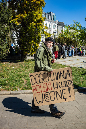 A protester marches with a placard that says, in Polish, "Enough of pushing Poland into another war" during the demonstration. On the afternoon of the 1st of May, Polish workers, activists, and trade unionists come together on International Workers Day for a demonstration organized by the All-Poland Trade Union Workers' Initiative (OZZIP) under the slogan "Enough with the ban on strikes. Time for strong trade unions". The current Polish law regulating collective disputes and strikes is based on restrictions dating back to martial law, and the demonstration seeks to promote modernising the regulations. Protesters march through Warsaw with flags and placards, while chanting anti-capitalist slogans.