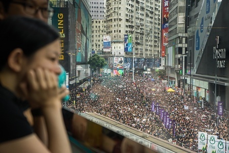 A young lady watched hundreds of thousands of protesters marching through the streets of Hong Kong during the mass rally, which called for, among other demands, the withdrawal of the controversial extradition bill and the resignation of Chief Executive Carrie Lam.
Despite the Chief Executive Carrie Lam's attempt to ease the heightened tension by agreeing to suspend the controversial bill, close to 2 million people participated in Sunday's rally, according to the organizers. The protesters called for the withdrawal of the controversial extradition bill, the release and non-prosecution of the people arrested due to the cause, investigation of whether excessive force had been used by the police on June 12, and the resignation of Carrie Lam.