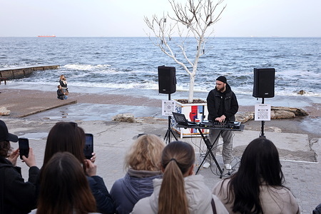 DJ USIK performs on the Langeron Beach promenade. Ukrainians are enjoying warm days on the Black Sea coast after severe cold weather and blackouts following Russia's shelling of energy infrastructure.