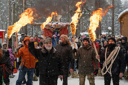 People take part in a torchlight procession carrying an effigy of Maslenitsa to the burning site during celebrations of Maslenitsa (Shrovetide), a traditional Russian folk festival marking the end of winter, at Emerald Lake in the village of Toksovo in the Leningrad region.