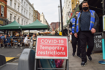 Covid-19 marshals walk past a Covid-19 road sign in Old Compton Street, Soho.
Several streets in Central London have been blocked for traffic at certain times of the day to allow outdoor, al fresco seating at bars and restaurants.