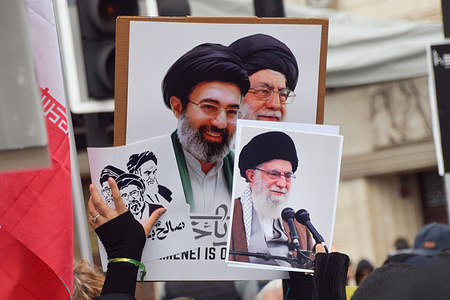 A protester holds up pictures of Ali Khamenei and Mojtaba Khamenei during the Al-Quds Day rally in Albert Embankment. The annual protest, originally planned as a march, was changed to a static rally following the government's ban of the march.