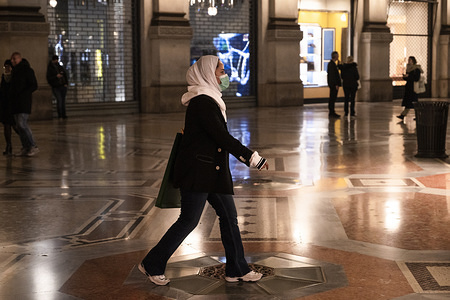 MILAN, ITALY - FEBRUARY 25, 2020:
A lady walks while wearing a protective mask amid coronavirus fears.
Following the regional decree demanding the closure after 18:00 of bars, discotheques, pubs and also museums, cinemas, as a drastic measure for containing the spreading of COVID-19, only restaurants and commercial places were left open. The ban will last, at least, seven days (until March, the 1st).