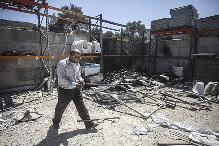A Palestinian man inspects the damages to a commercial warehouse of sanitary building materials that was burned by Jewish settlers from the Israeli settlement of Homesh. A group of masked settlers attacked shops and homes in the village of Bazaria, north of the city of Nablus in the West Bank.