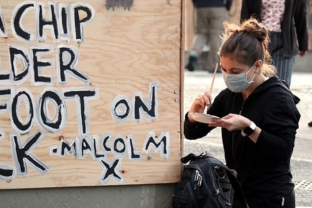 A woman paints a barricade inside the so-called "Capitol Hill Autonomous Zone" in Seattle.
The area surrounding Seattle's East Precinct police station, which last week Mayor Jenny Durkan ordered to be evacuated and surrendered to protesters, is operating as a semi-autonomous jurisdiction outside the control of state authorities.