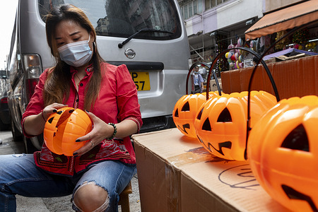 A gift and decorative product store vendor put together Halloween pumpkin theme baskets to sell on Halloween day.