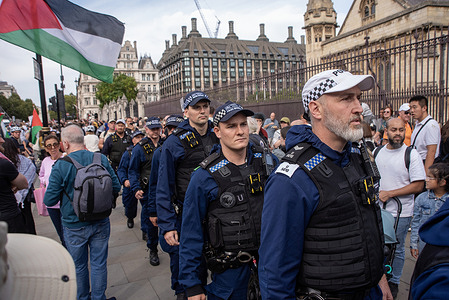 Police officers walk through the crowd at the Parliament Square. Demonstrators gathered at the Parliament Square. The protesters aim was to show their support to the Palestine Action and to demand from the British government to take the organisation off from the terrorist list.